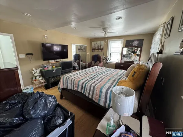 a spacious bedroom with bed and a flat screen tv