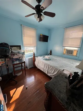 a bedroom with a bed wooden floor and window