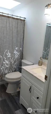 a bathroom with a toilet a sink and mirror