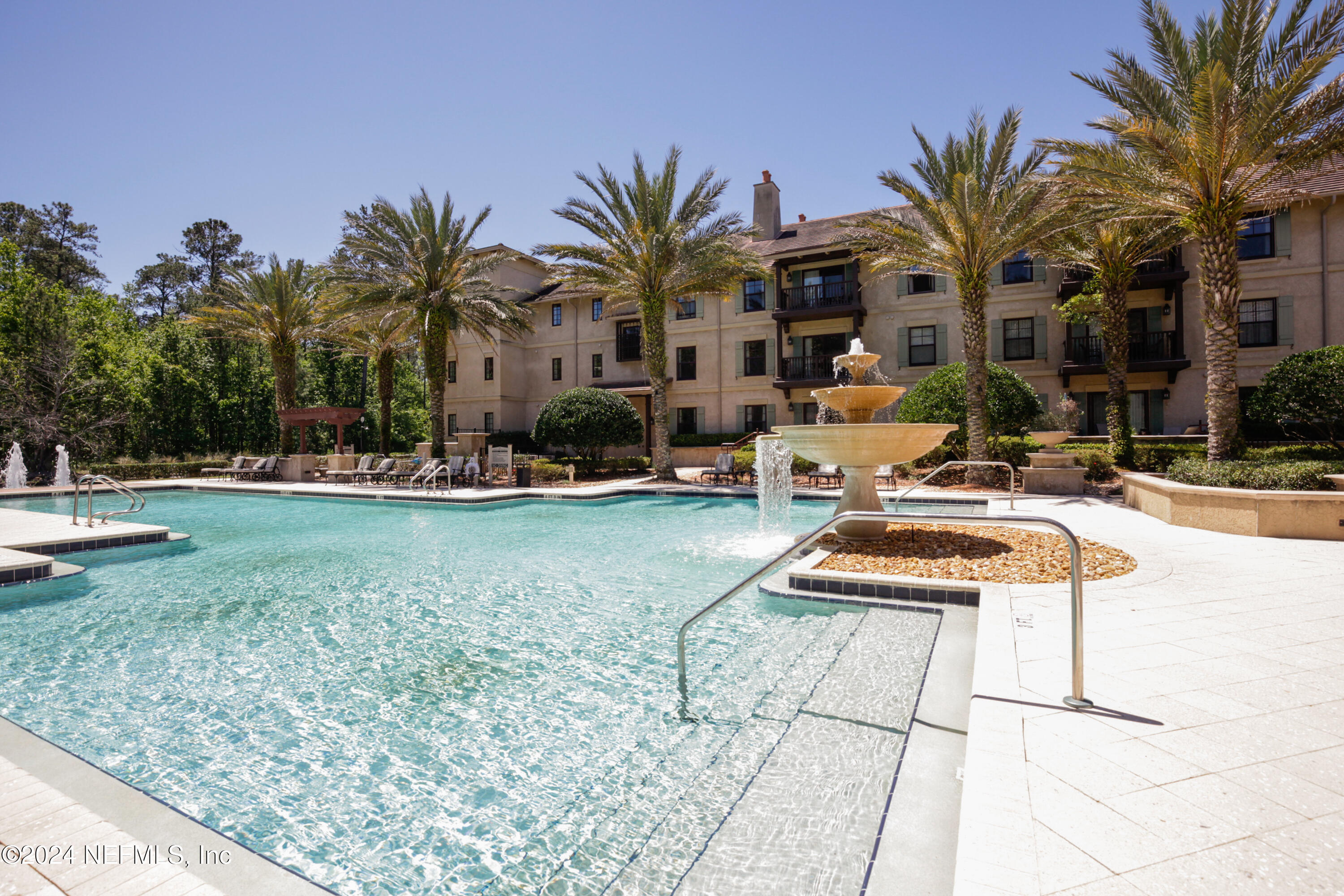 955 Registry Boulevard, Unit 308 St. Augustine, FL 32092 - Photo 36 of 55 a view of a swimming pool with chairs and palm tree