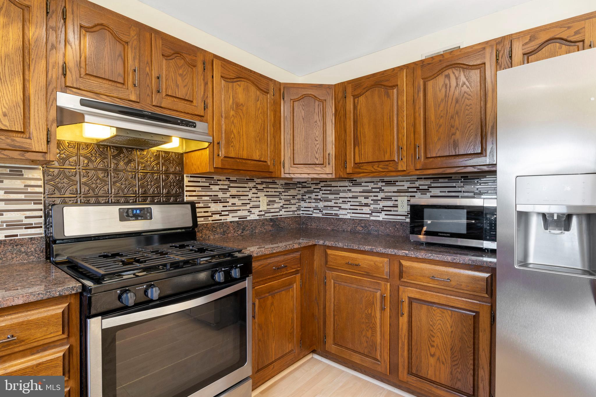 503 Chambers Ridge York, PA 17402 - Photo 10 of 34 a kitchen with granite countertop wooden cabinets and stainless steel appliances