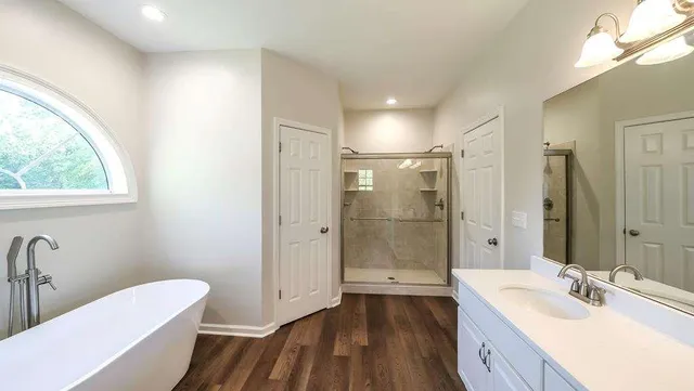 a bathroom with a granite countertop sink mirror bathtub and toilet