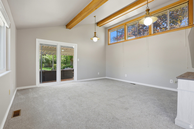 4245 3320 East Holladay, UT 84124 - Photo 17 of 51 Spacious room featuring vaulted ceilings with exposed wood beams, light grey carpet, and neutral paint