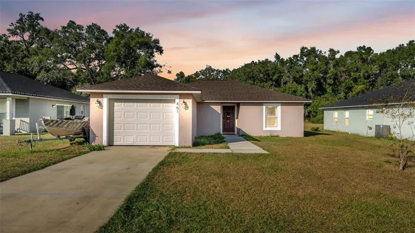 a view of a house with backyard and trees