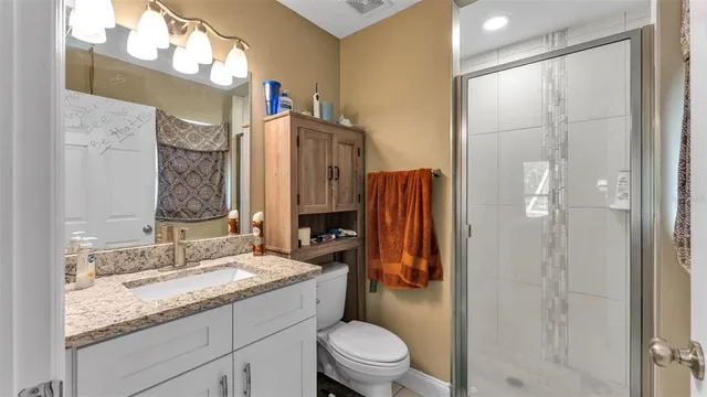 a bathroom with a granite countertop sink toilet and shower