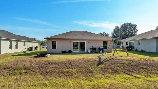 a view of a house with backyard and a tree