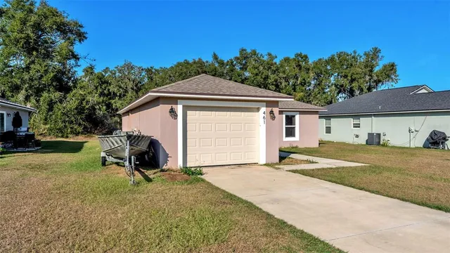 a view of a house with backyard and a tree