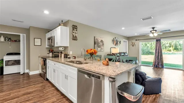 a open kitchen with stainless steel appliances granite countertop a stove and more cabinets