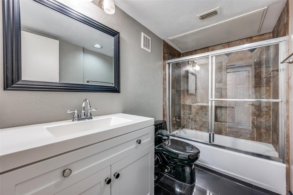 4517 North O'Connor Road, Unit 1138 Irving, TX 75062 - Photo 18 of 24 Full bathroom with a textured ceiling, toilet, tile patterned floors, bath / shower combo with glass door, and vanity