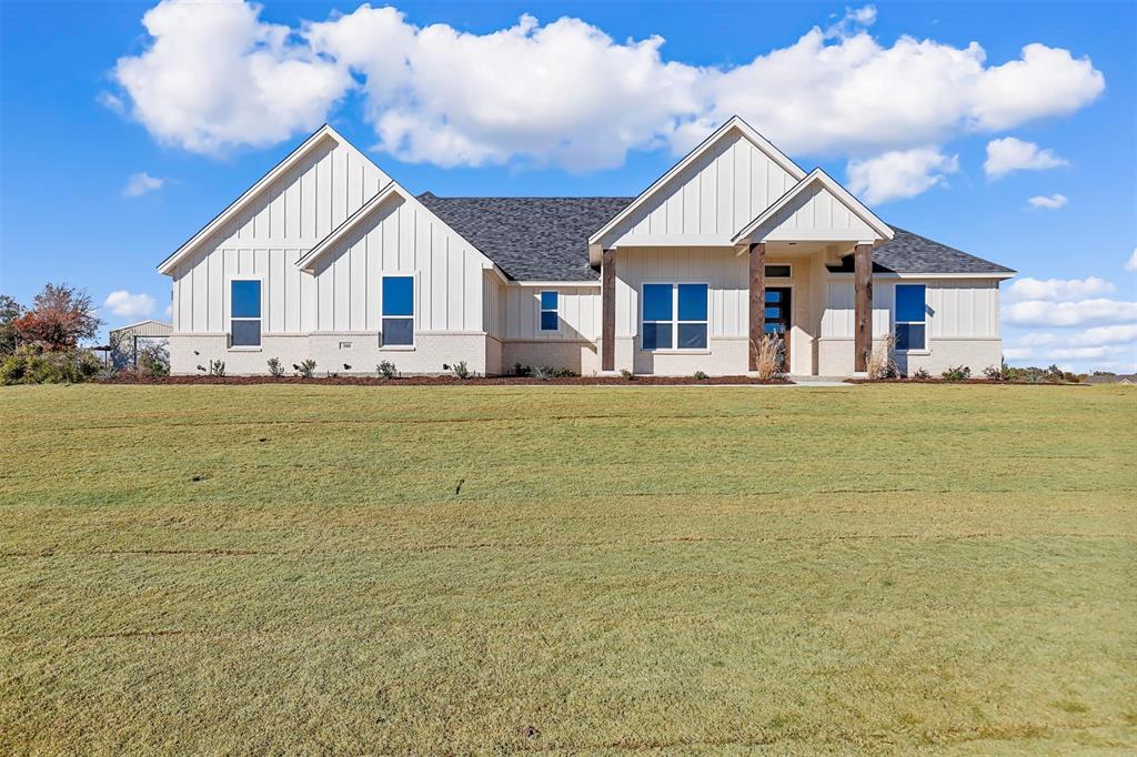 a view of a house with a big yard and large trees