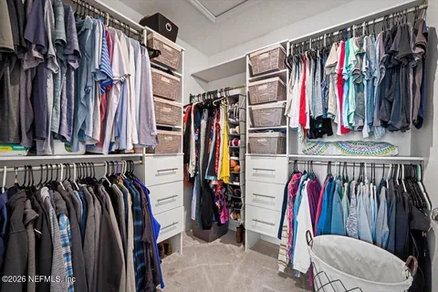 a view of walk in closet with clothes