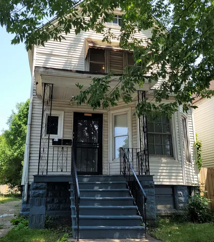 a front view of a house with a tree