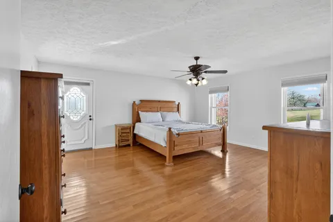 a bedroom with a bed and dresser with mirror