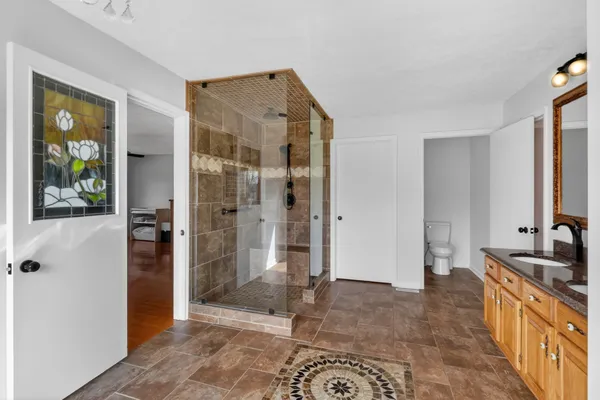 a living room with granite countertop kitchen island a sink and a stove with wooden floor