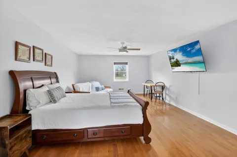 a view of empty room with wooden floor and fan