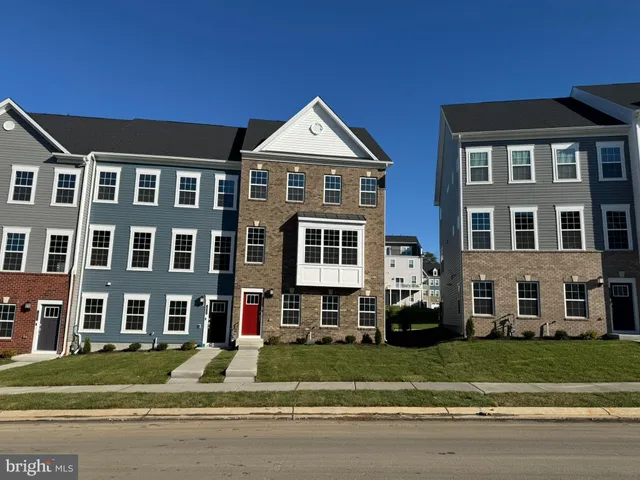 a front view of residential houses with a yard