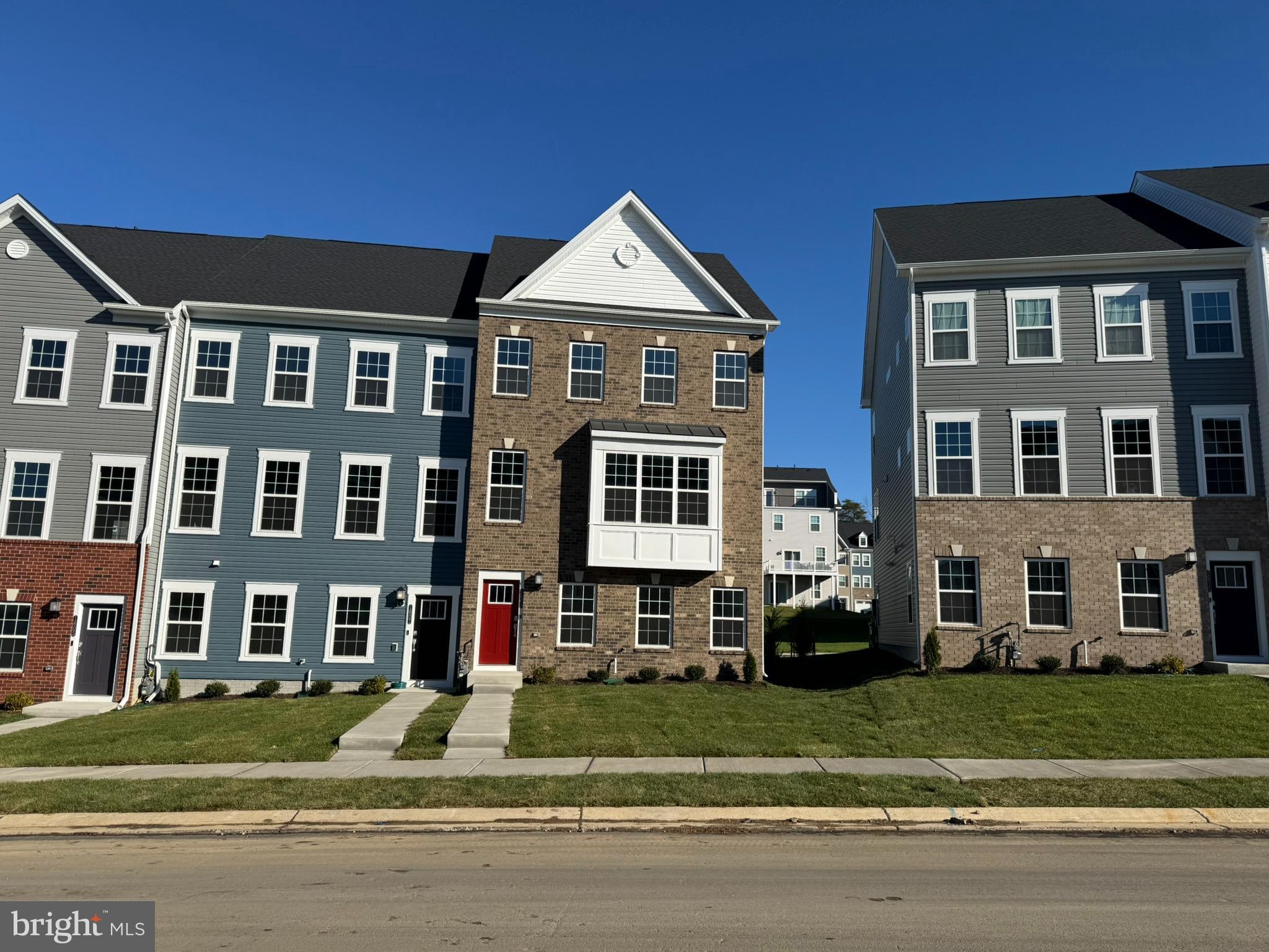 a front view of residential houses with a yard