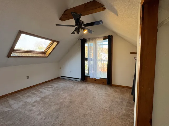 an empty room with ceiling fan and window