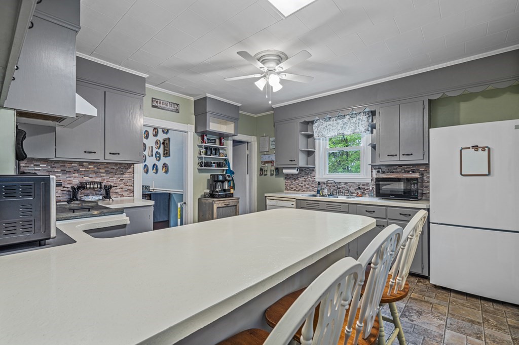 569 Gaskill Street Woonsocket, RI 02895 - Photo 5 of 33 a kitchen with kitchen island a stove a chandelier and a refrigerator