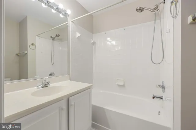 a bathroom with a sink a mirror a shower and a bathtub
