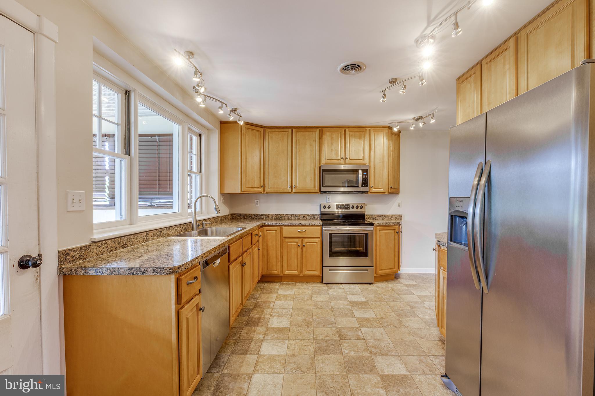 402 West Pearl Street Rising Sun, MD 21911 - Photo 10 of 23 a kitchen with stainless steel appliances granite countertop a refrigerator a sink a stove with cabinets and wooden floor