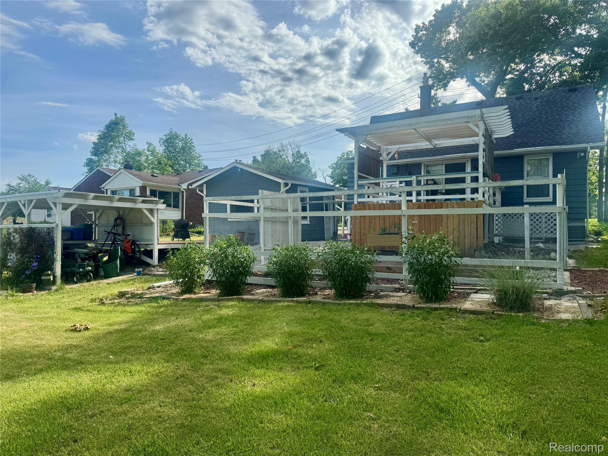 22827 Meridian Road Grosse Ile, MI 48138 - Photo 5 of 36 Expansive rear yard featuring a large deck with white railings and a pergola