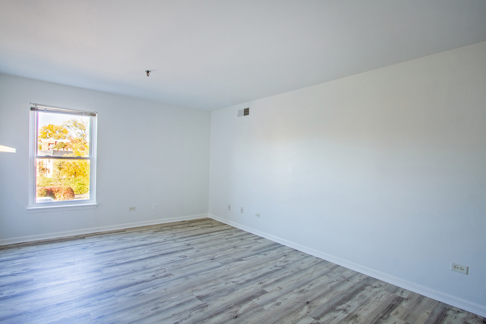 3265 Kirchoff Road, Unit 223 Rolling Meadows, IL 60008 - Photo 11 of 12 a view of an empty room with wooden floor and window