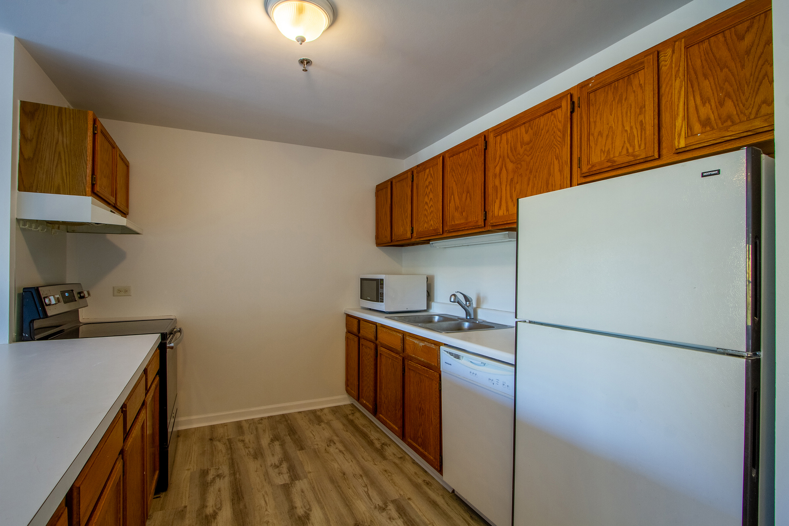 3265 Kirchoff Road, Unit 223 Rolling Meadows, IL 60008 - Photo 5 of 12 a kitchen with stainless steel appliances granite countertop a refrigerator a sink dishwasher a stove with wooden cabinets
