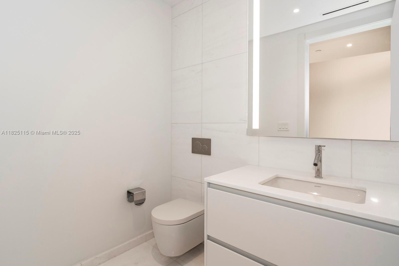 300 Biscayne Blvd Way, Unit 3902 Miami, FL 33131 - Photo 21 of 41 a bathroom with a toilet a sink and mirror