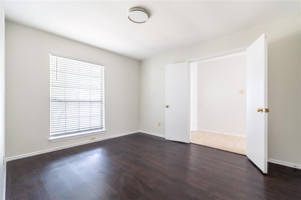 809 Simon Drive Plano, TX 75025 - Photo 5 of 24 an empty room with wooden floor and windows