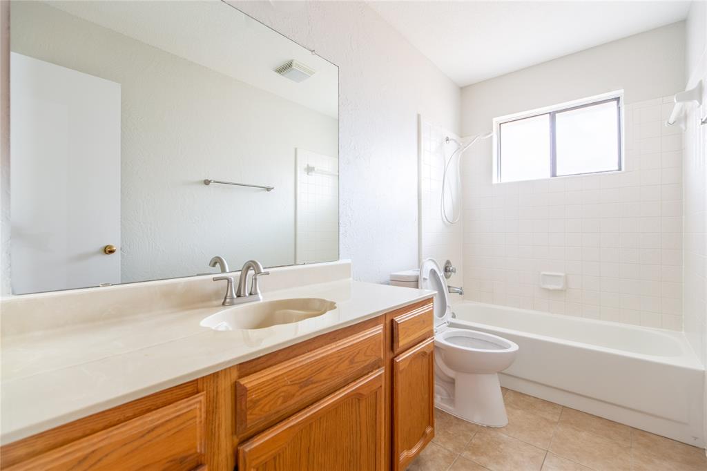 809 Simon Drive Plano, TX 75025 - Photo 7 of 24 a bathroom with a granite countertop sink a toilet and bathtub