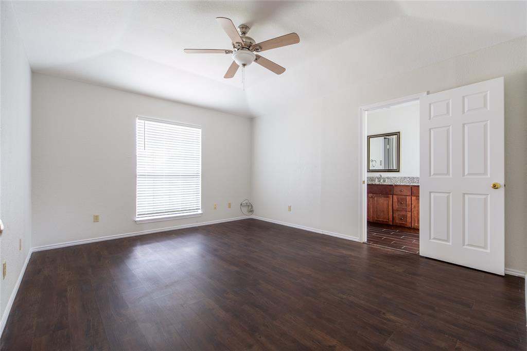 809 Simon Drive Plano, TX 75025 - Photo 8 of 24 an empty room with wooden floor chandelier fan and windows