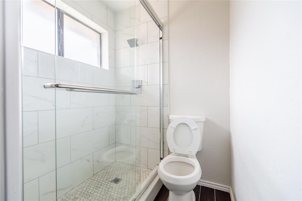 809 Simon Drive Plano, TX 75025 - Photo 10 of 24 a bathroom with a toilet and a shower