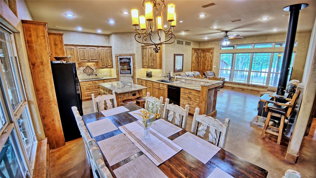 4509 Lazy E Road St. Jo, TX 76265 - Photo 32 of 39 a view of a dining room with furniture a chandelier and wooden floor