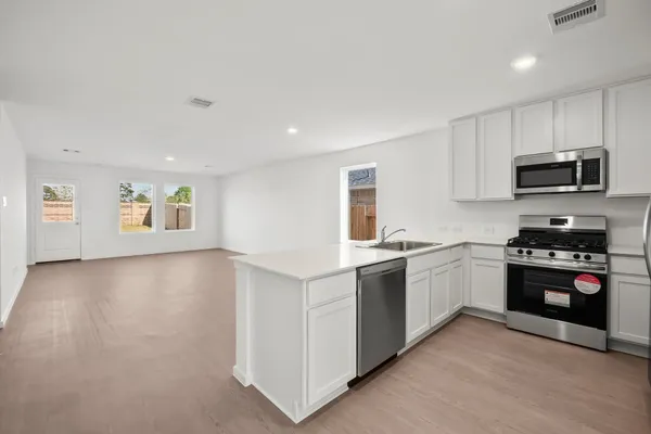 a kitchen with granite countertop a stove top oven and sink