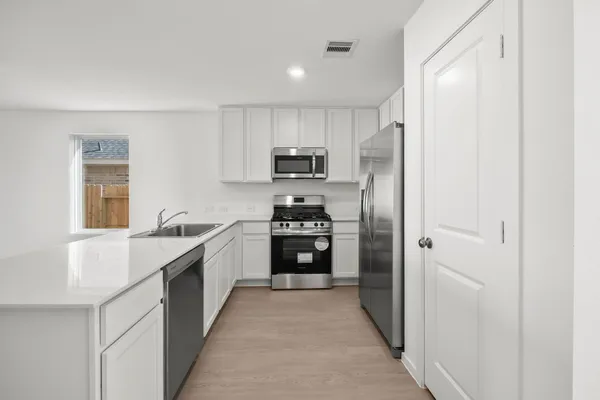 a kitchen with stainless steel appliances granite countertop a refrigerator and a stove top oven