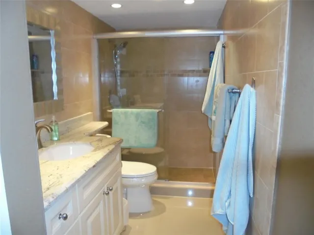 a bathroom with a granite countertop sink toilet and shower