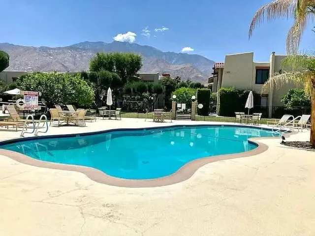 a view of a swimming pool with a yard and mountain view