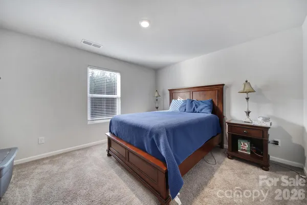 a spacious bedroom with a bed and a window