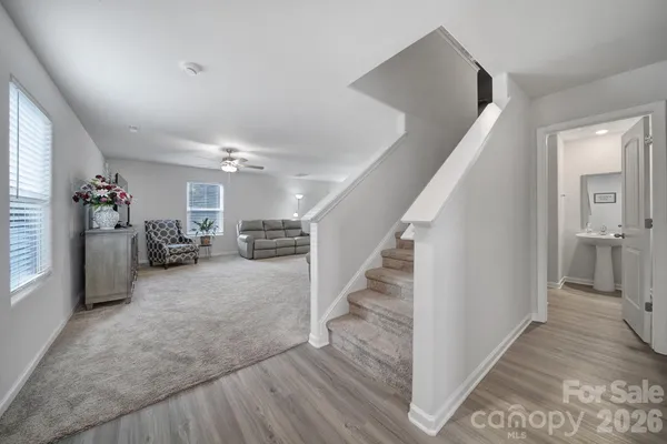 a view of a hallway with closet and a living room