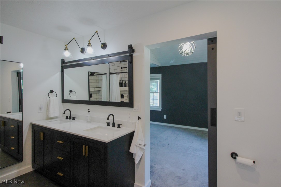 207 Harmon Road Aurora, OH 44202 - Photo 21 of 40 Primary bathroom with dual vanity and view of the bedroom beyond.