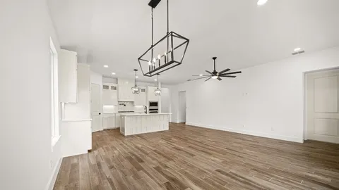 a view of a kitchen with a sink and dishwasher a refrigerator with wooden floor