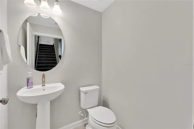 a bathroom with a toilet a sink and mirror