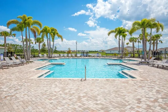 a view of a swimming pool with a lounge chair and tables