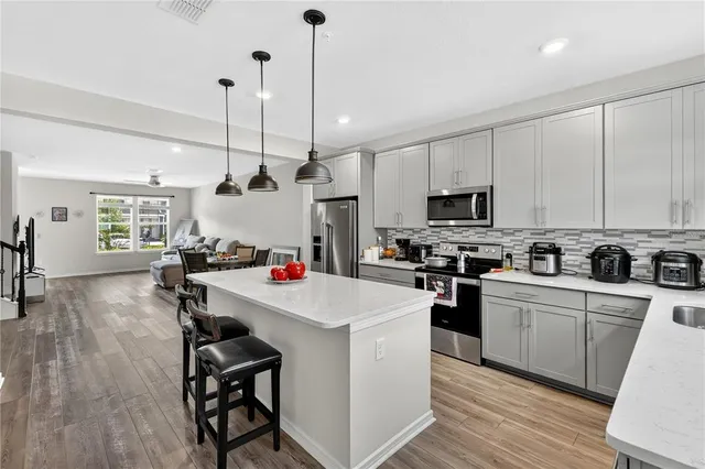 a kitchen with a sink a counter space appliances and cabinets