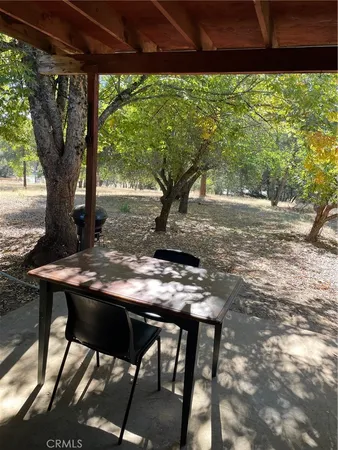 a view of a yard with table and chairs under an umbrella