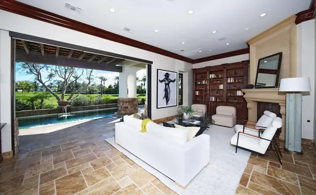 a living room with furniture kitchen view and a large window