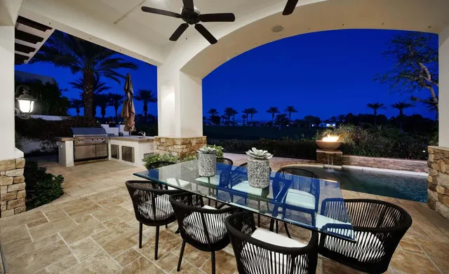 a view of a patio with couches table and chairs with potted plants and a big yard