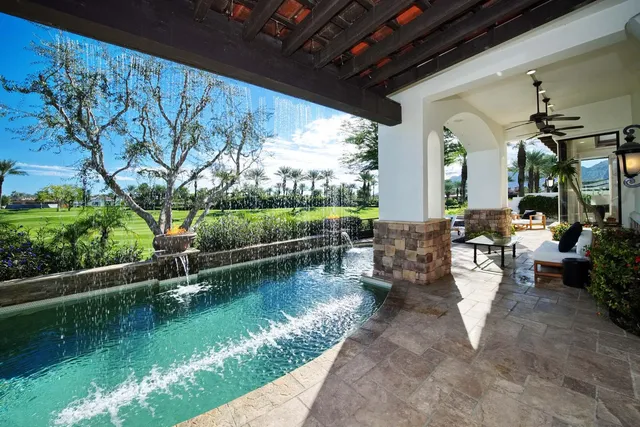a living room with furniture kitchen view and a large window