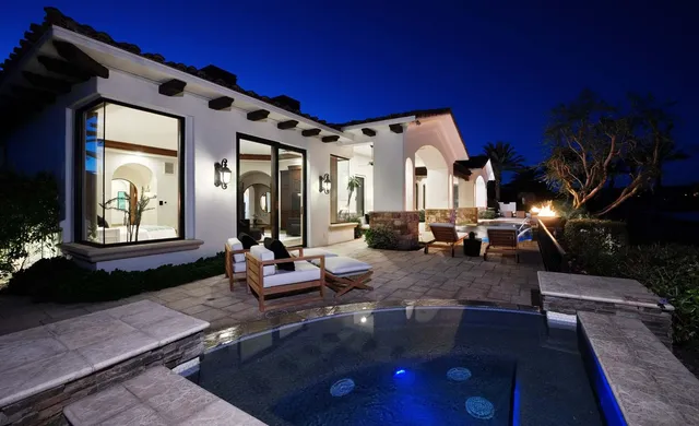 a large white kitchen with stainless steel appliances granite countertop a large stove a sink dishwasher and white cabinets next to a large window